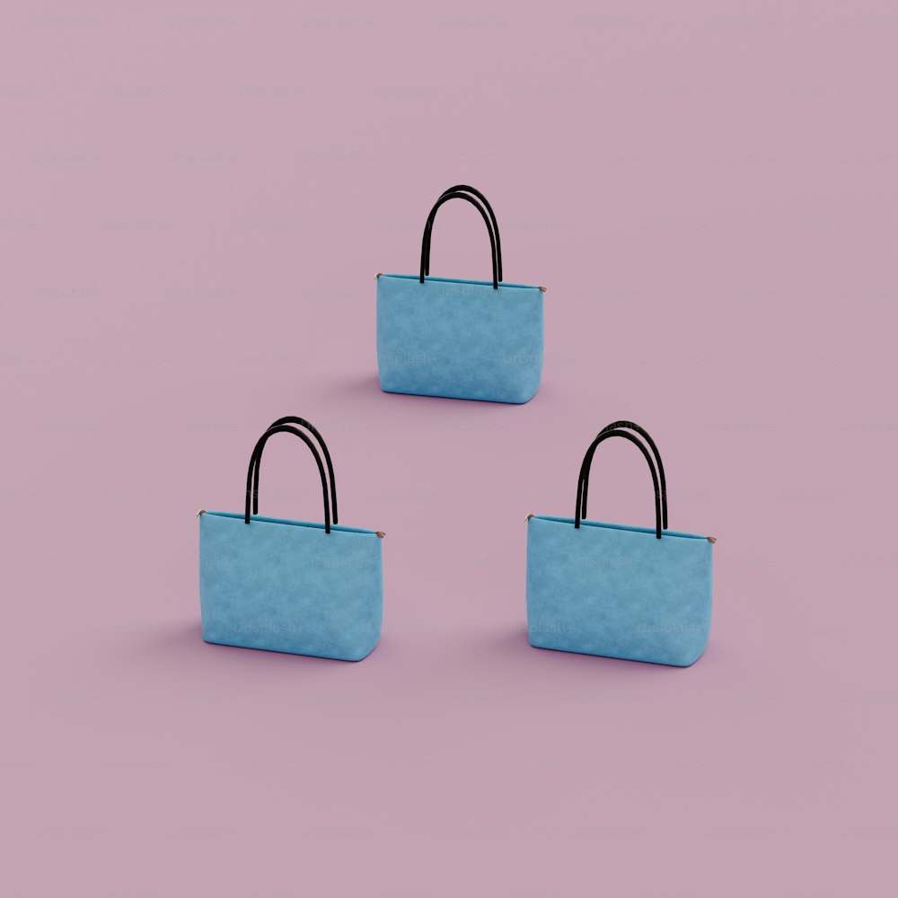 Tre borse blu sedute sopra una superficie rosa