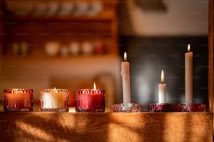 una fila di candele accese sedute sopra un tavolo di legno