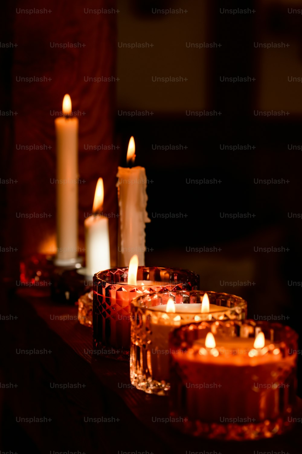 eine Gruppe brennender Kerzen, die auf einem Tisch sitzen