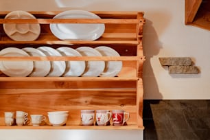 a wooden rack with plates and cups on it