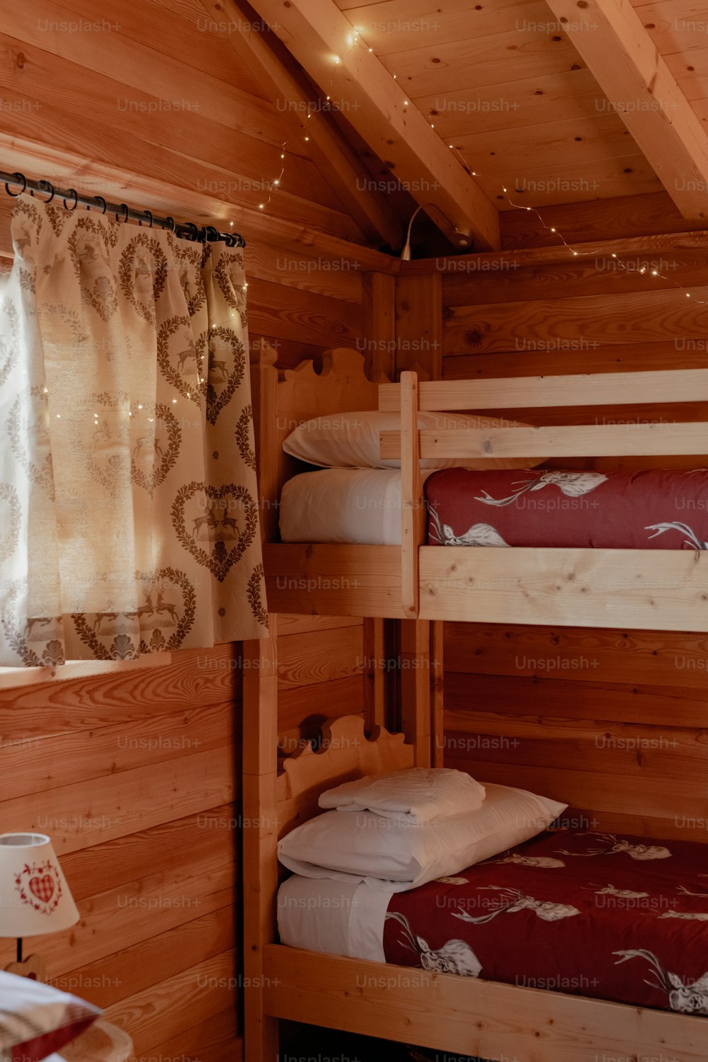 커튼과 조명이 있는 오두막의 이층 침대