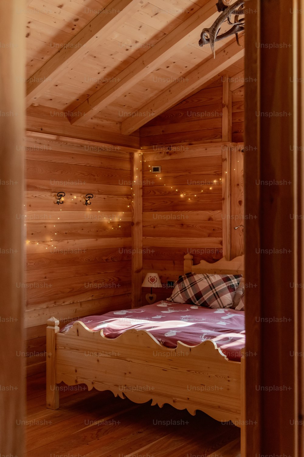 ein Bett in einem Zimmer mit Holzwänden