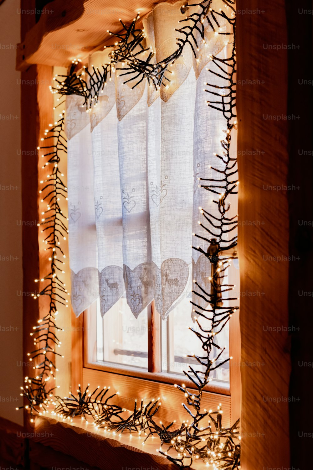 Una ventana decorada con luces navideñas y guirnaldas