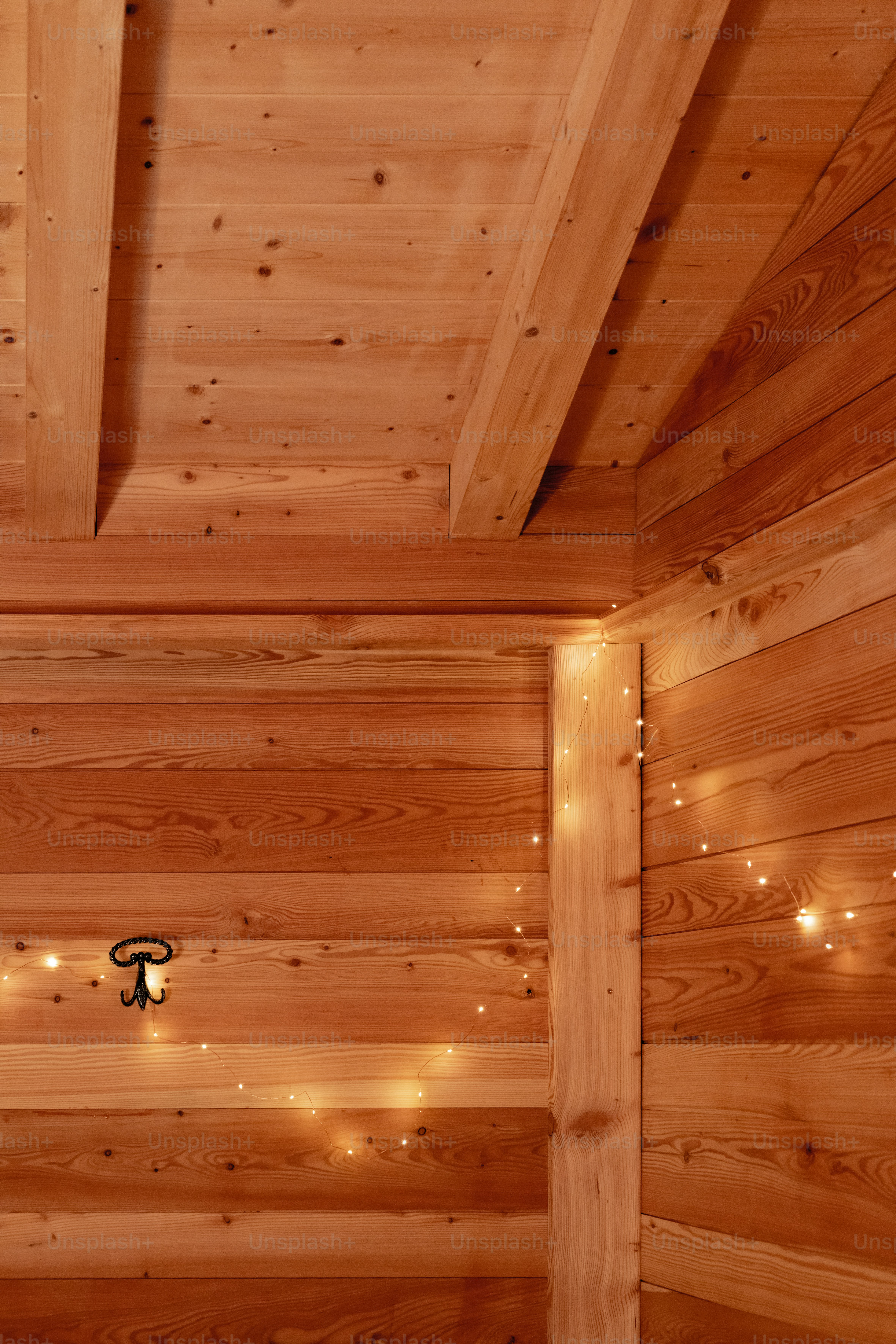 a bedroom with wooden walls and lights on the ceiling
