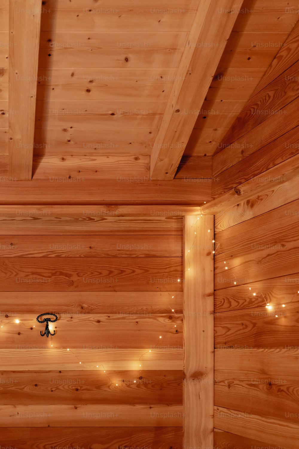 a bedroom with wooden walls and lights on the ceiling