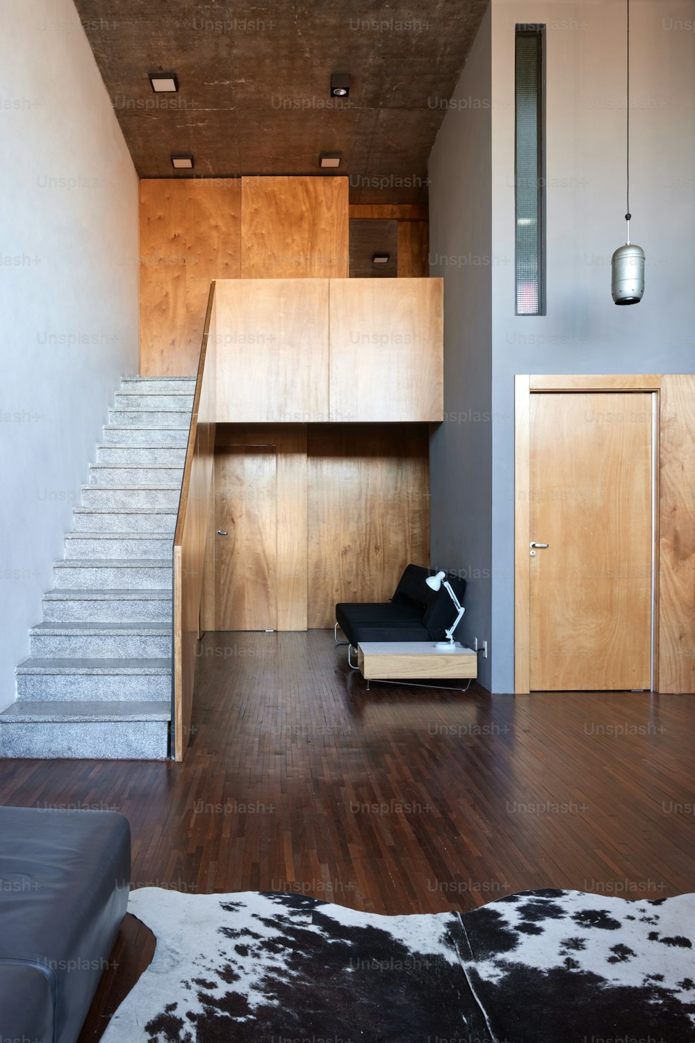a living room with wooden floors and a staircase