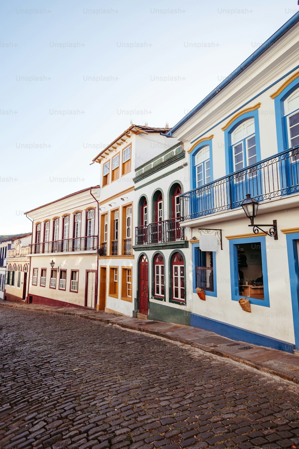a row of multi - colored buildings on a cobblestone street