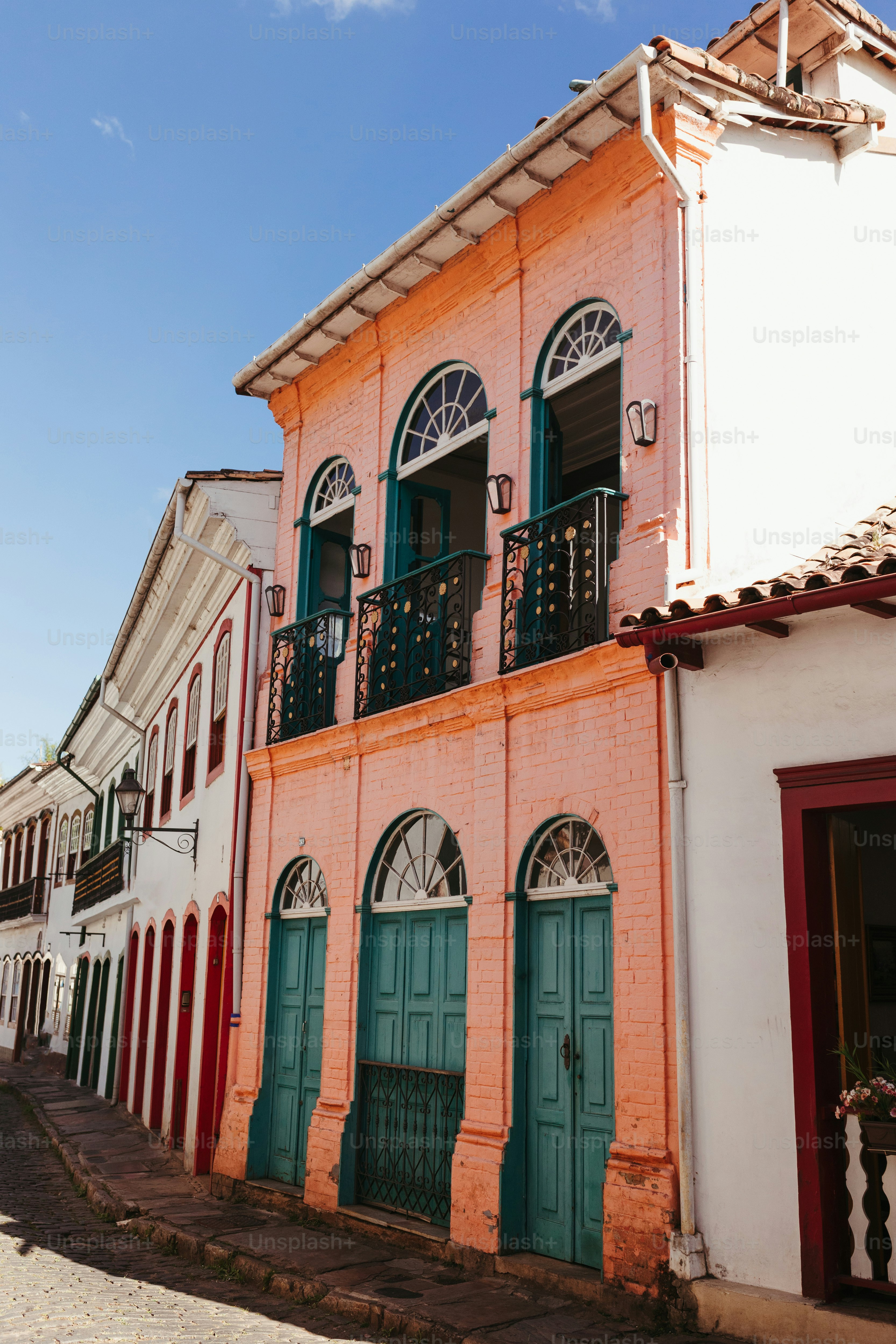 a row of buildings with green doors and windows