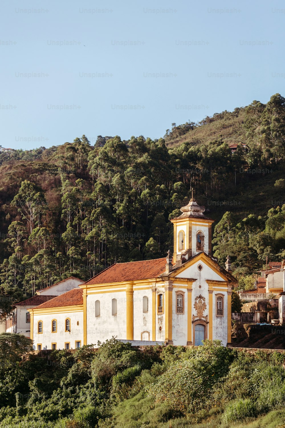 a church on a hill with trees in the background