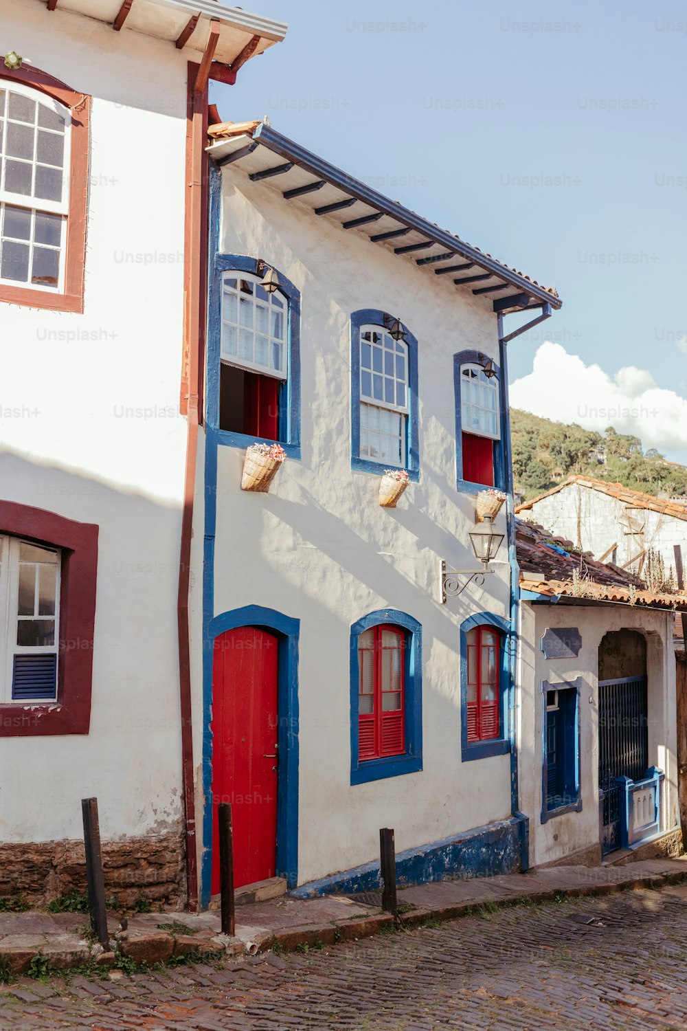 a white building with red and blue doors and windows