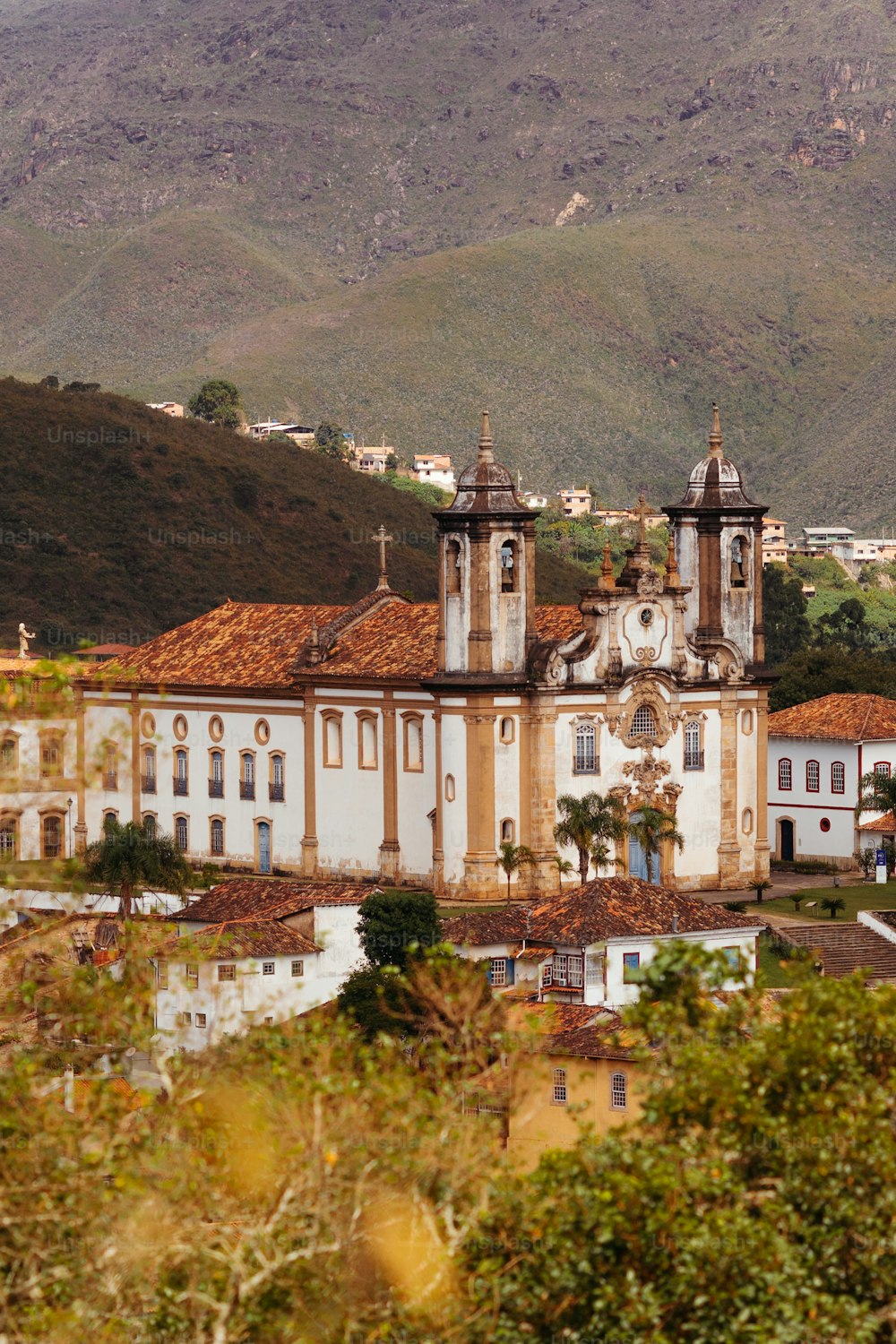 a large white building surrounded by mountains and trees