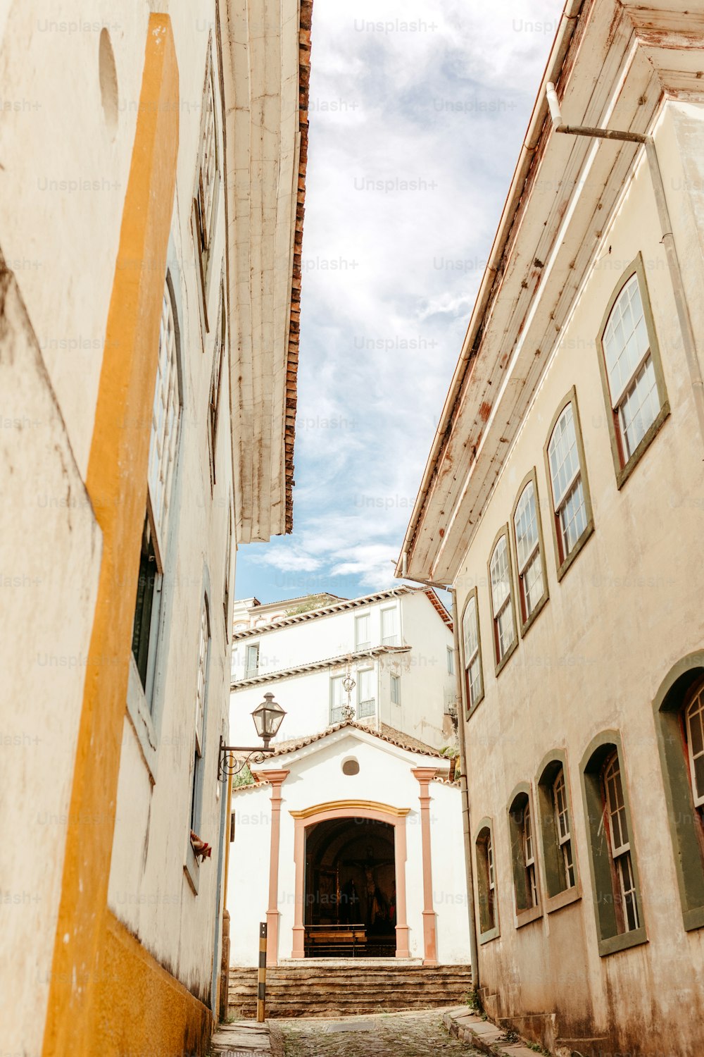 a narrow alley way with a building in the background