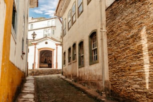 a narrow alley way with a church in the background