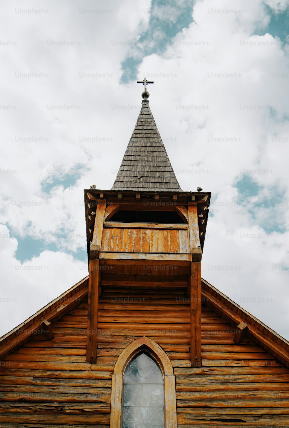 eine Holzkirche mit einem Turm und einem Kreuz auf der Spitze