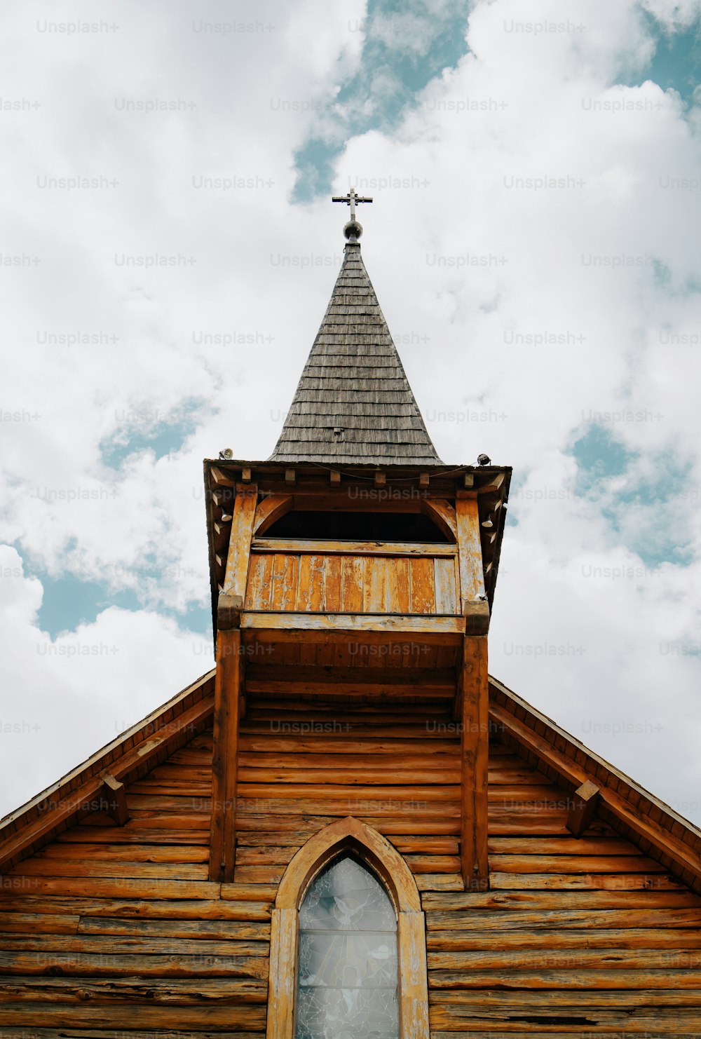 a wooden church with a steeple and a cross on top