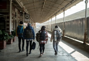 a group of people walking down a sidewalk next to a train