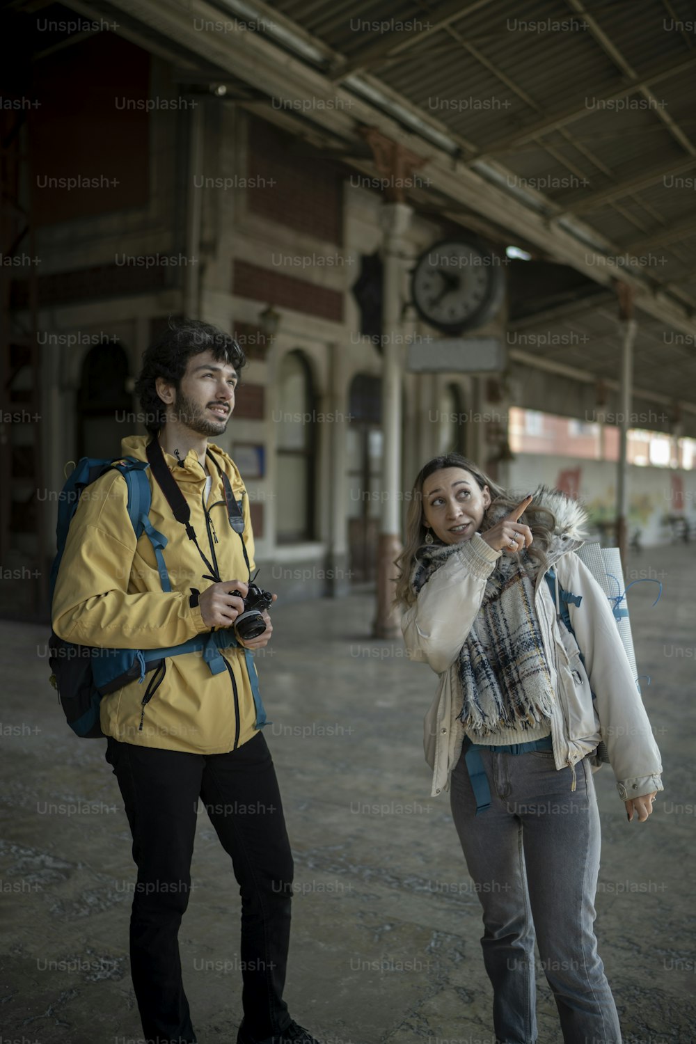a man standing next to a woman holding a camera