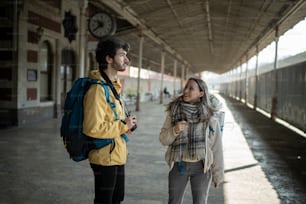 a man standing next to a woman in a train station
