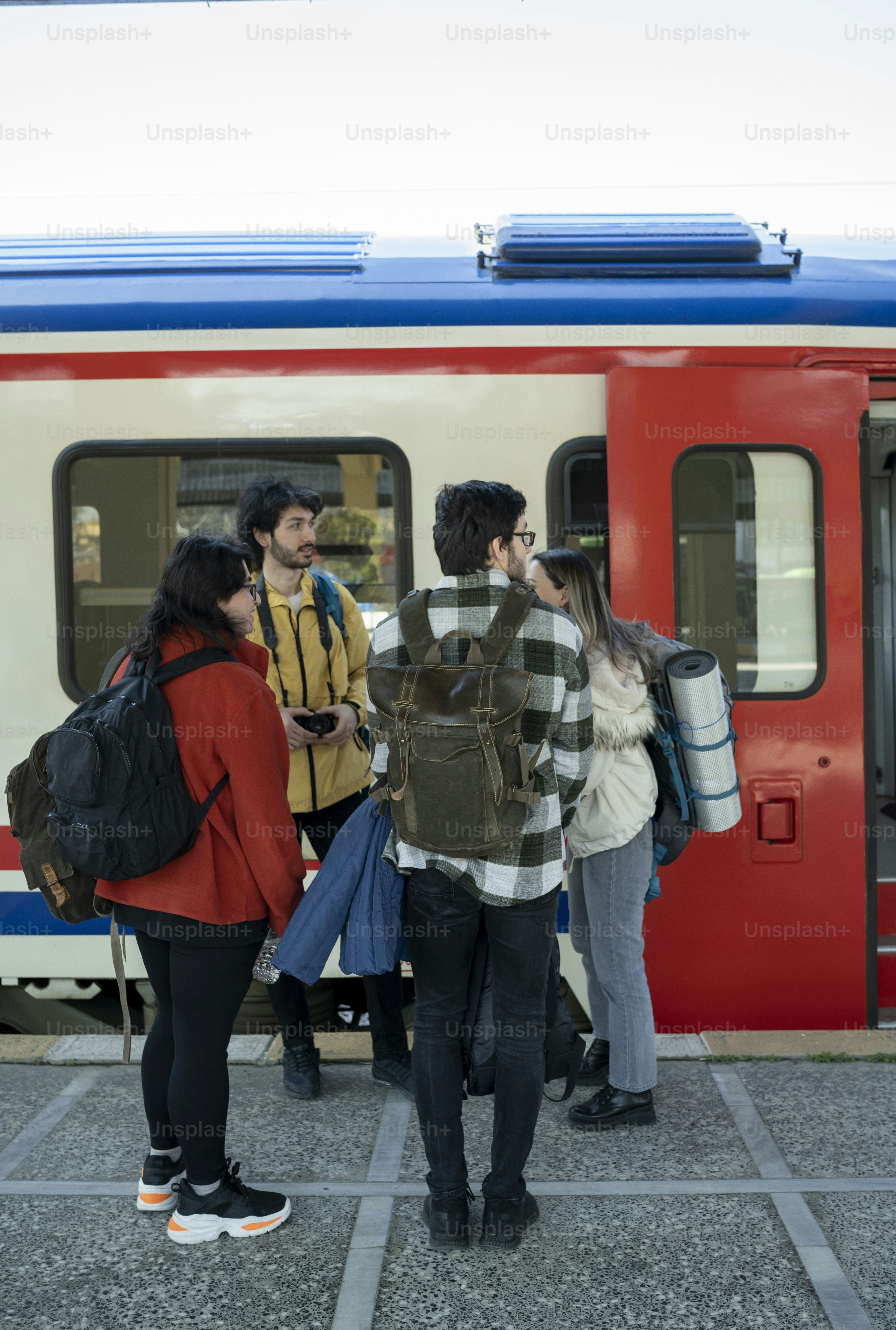 電車の前に立つ人々のグループ