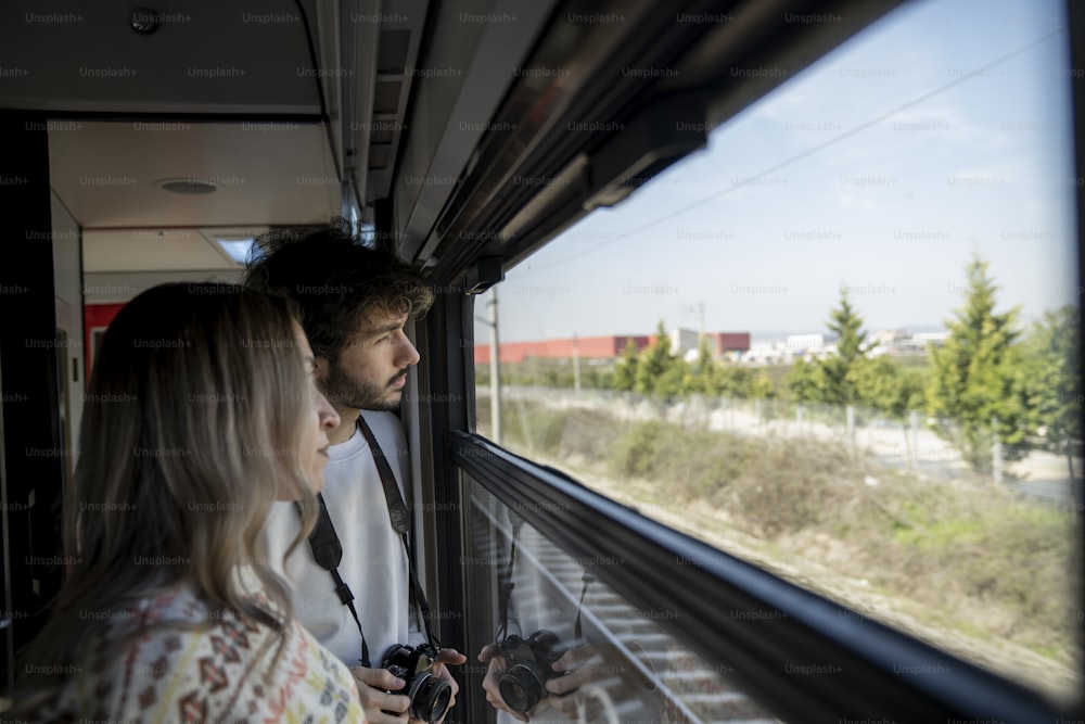 a man and a woman looking out a train window
