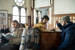 a group of people sitting around a table playing chess