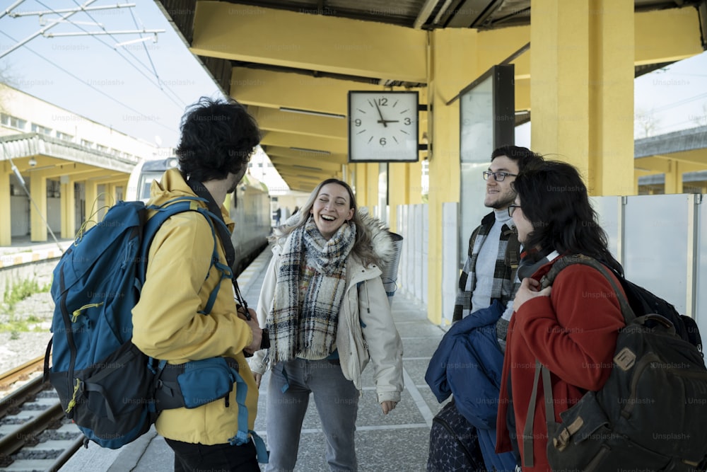 Un grupo de personas de pie junto a una estación de tren