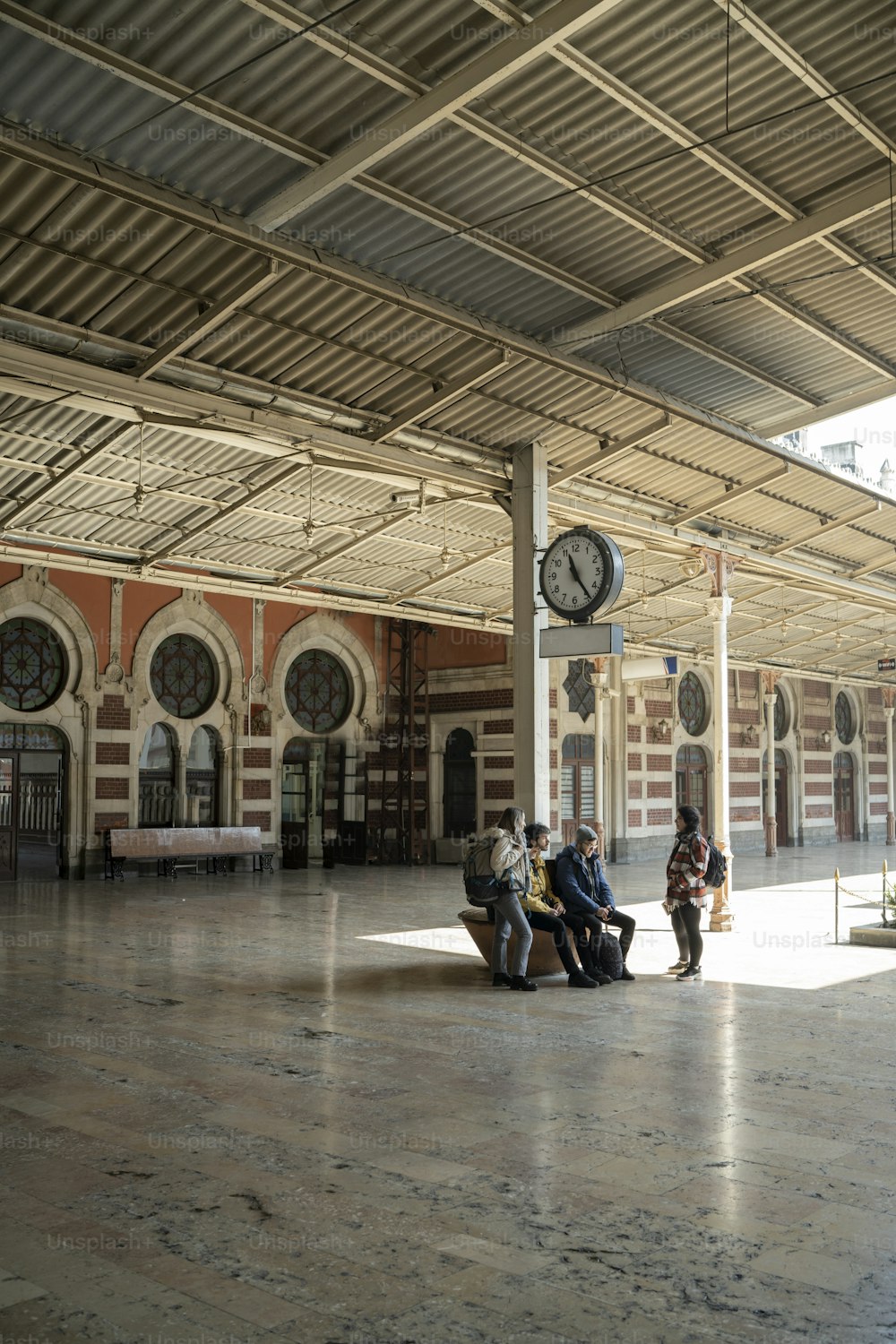 Un grupo de personas sentadas en un banco en una estación de tren