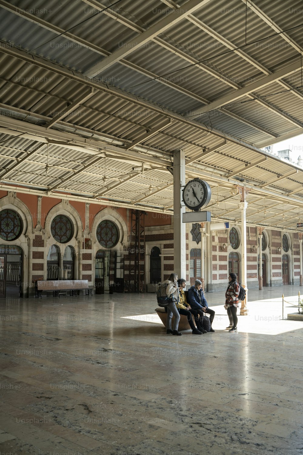 a group of people sitting on a bench in a train station