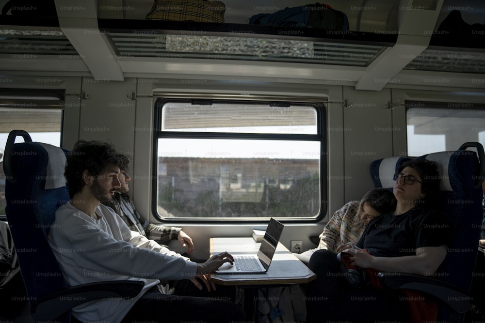 a group of people sitting around a table on a train