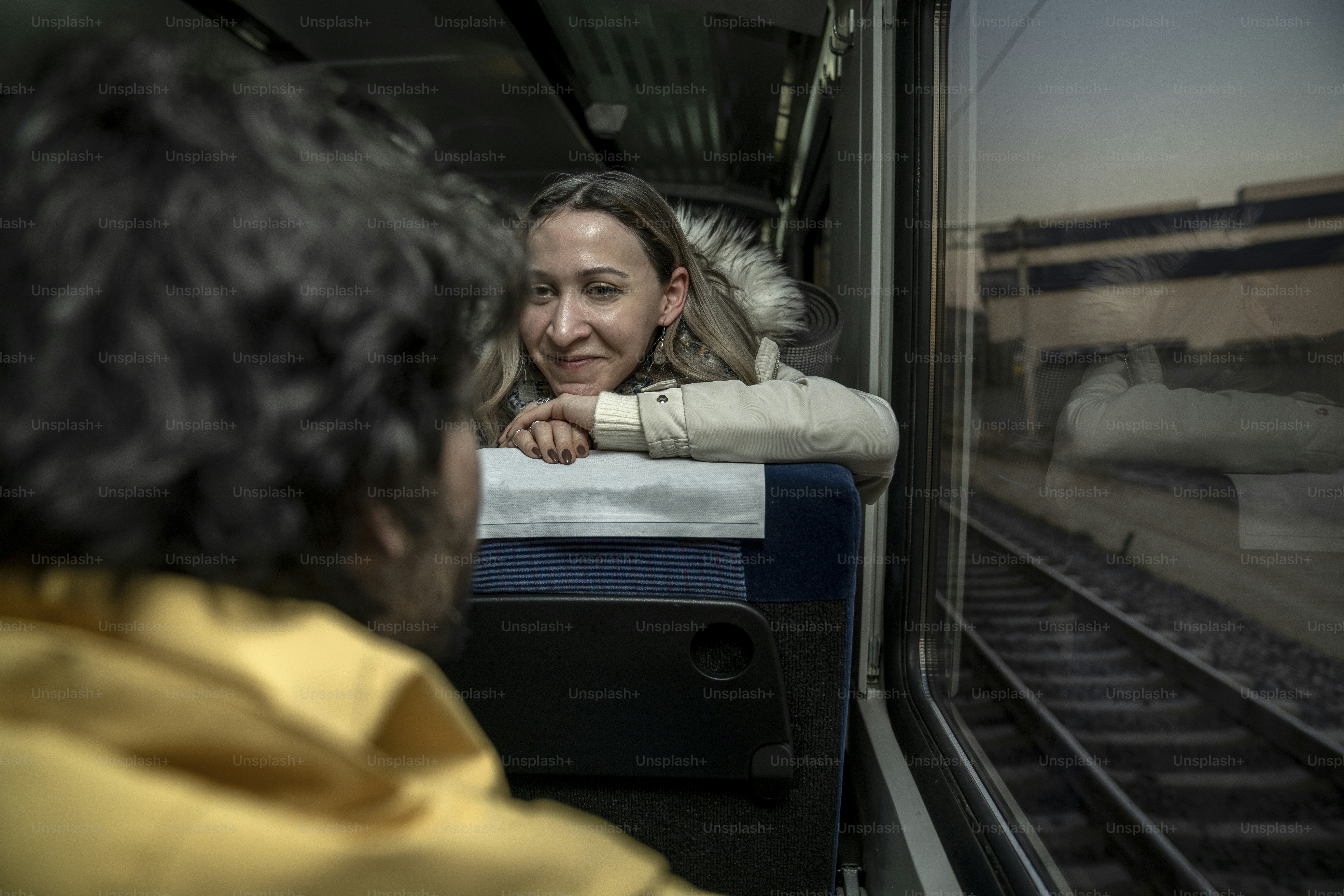 a woman sitting on a train looking out the window