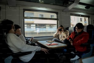 a group of people sitting on a train next to each other