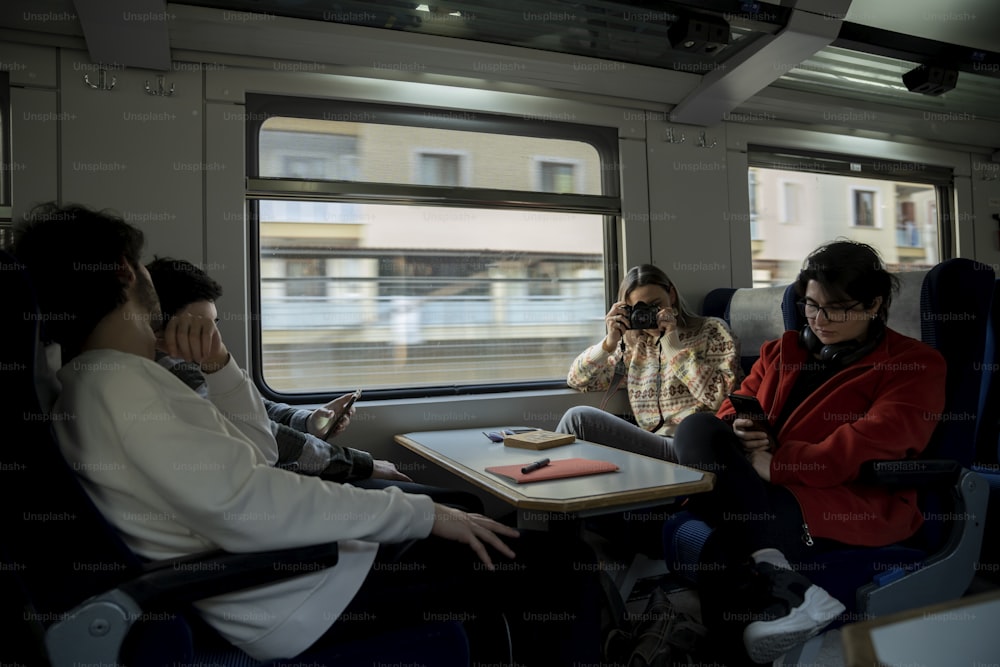 um grupo de pessoas sentadas em um trem ao lado do outro