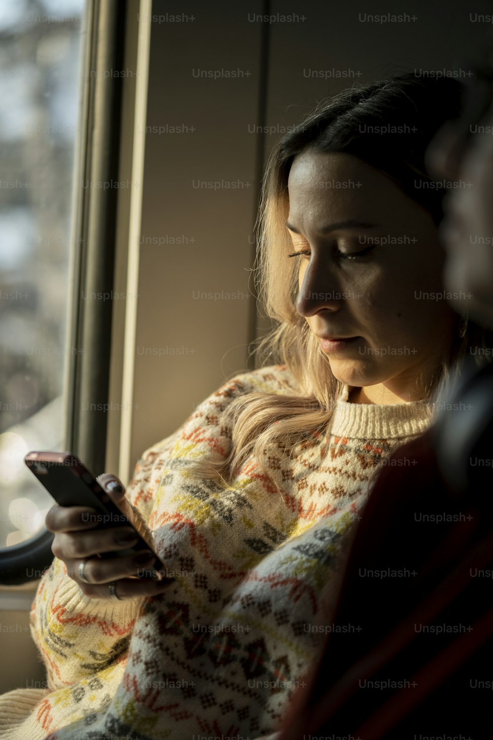 a woman sitting on a bus looking at her cell phone