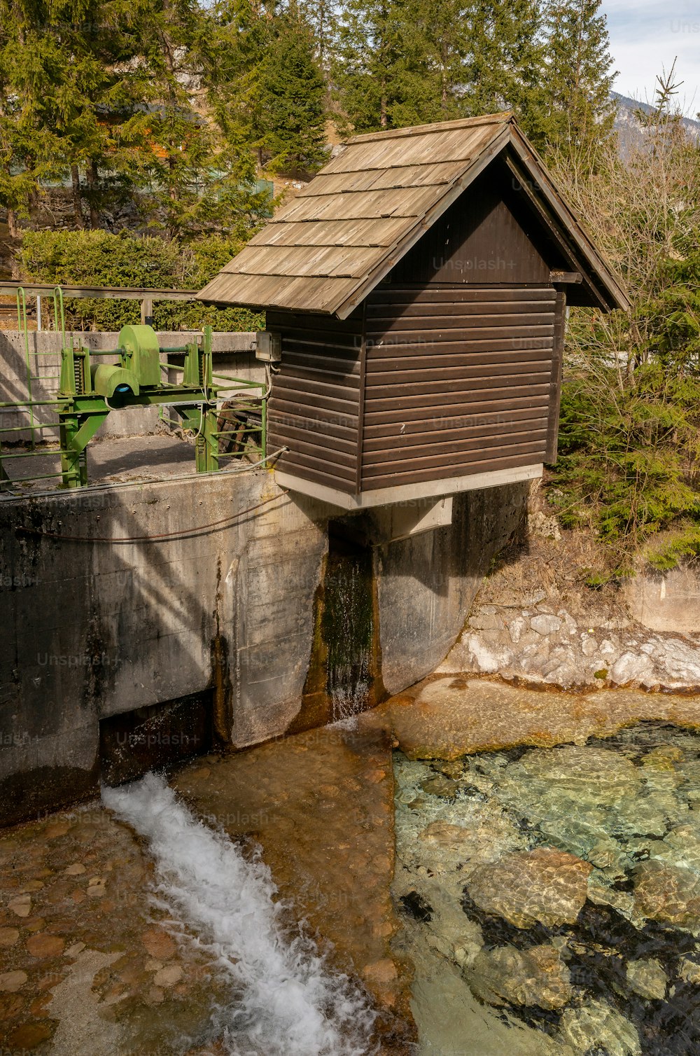 um pequeno edifício de madeira sentado no topo de um rio