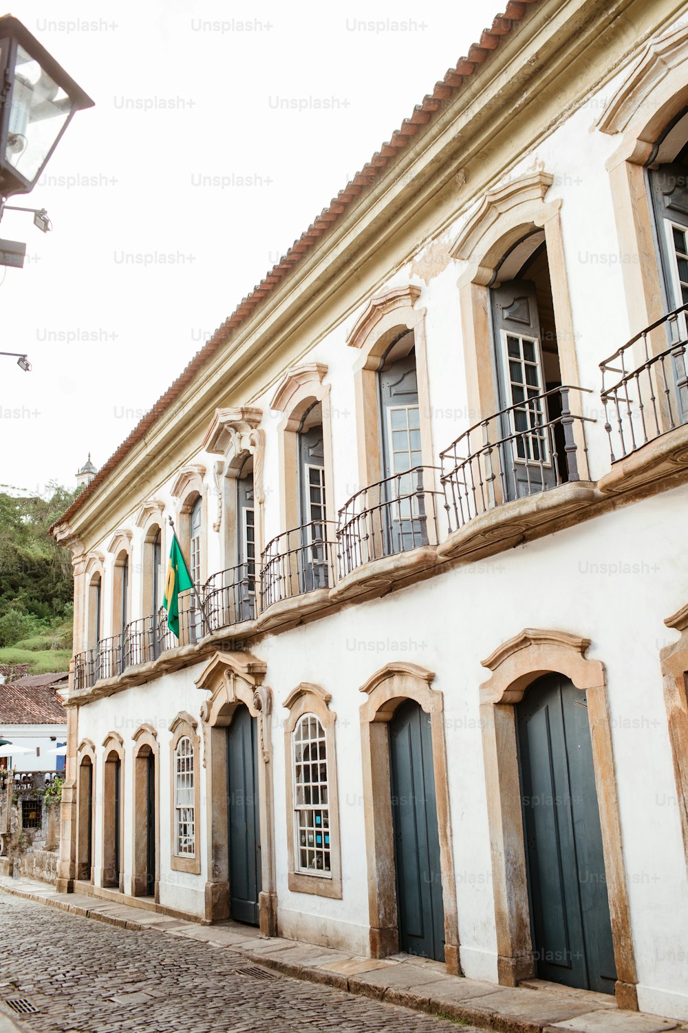 a white building with a green flag on the balcony