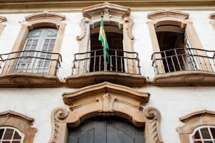 a building with two balconies and a green flag