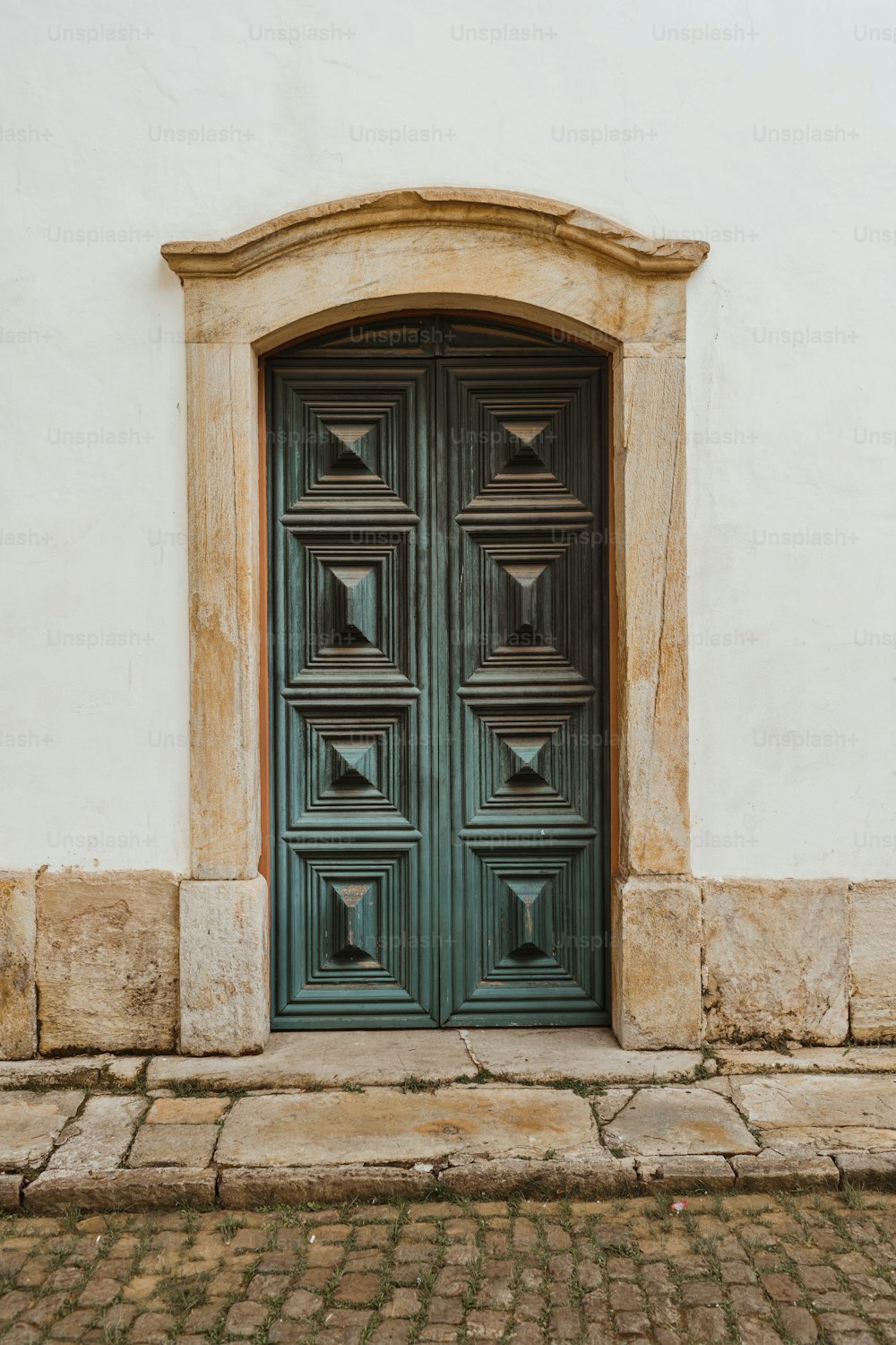 a large green door on the side of a building