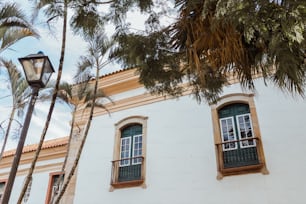 Ein weißes Gebäude mit zwei Fenstern und einer Straßenlaterne