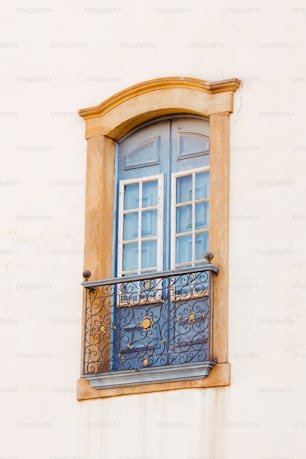 a balcony with a blue door and a window