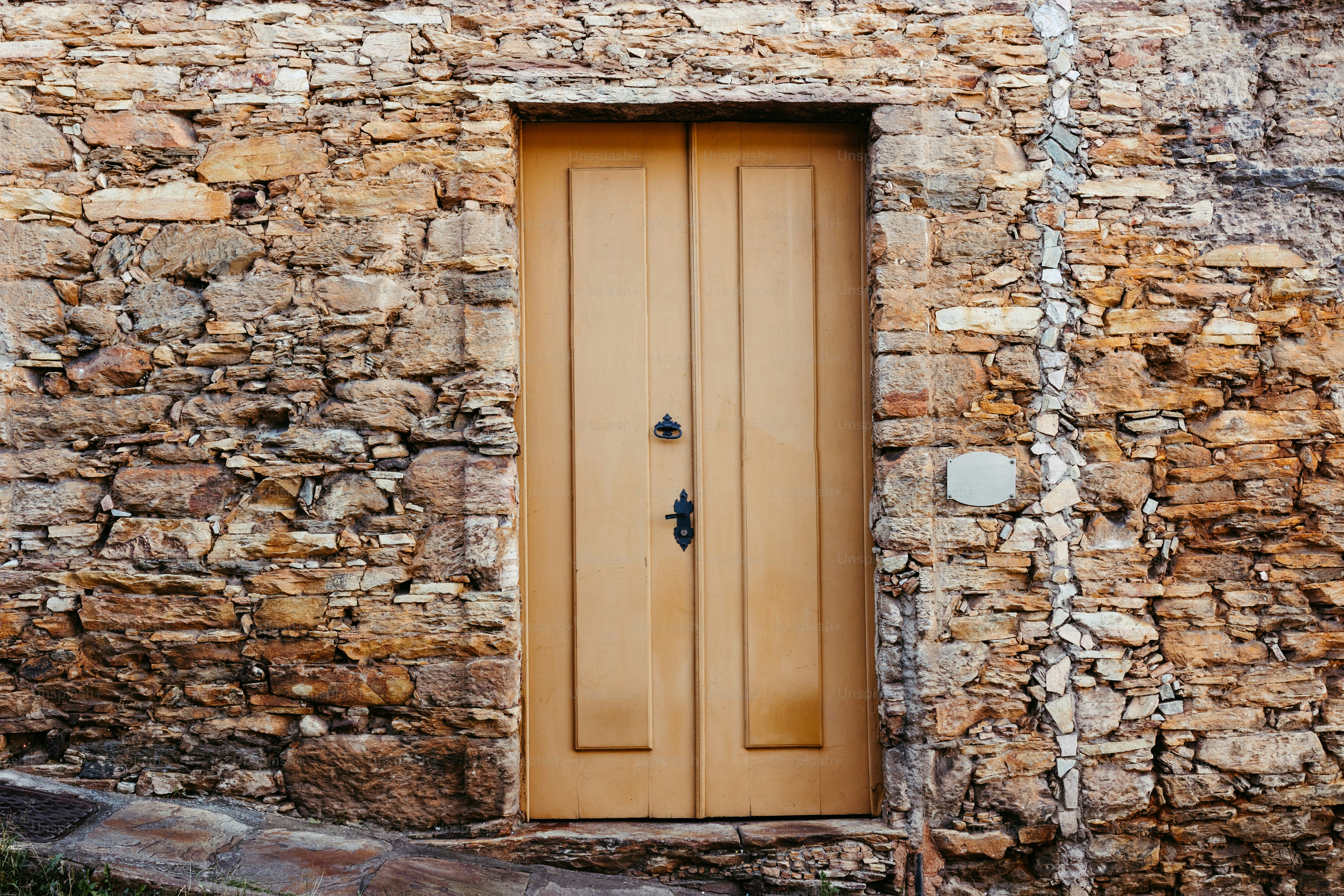 ein Steingebäude mit einer Holztür und einem Fenster