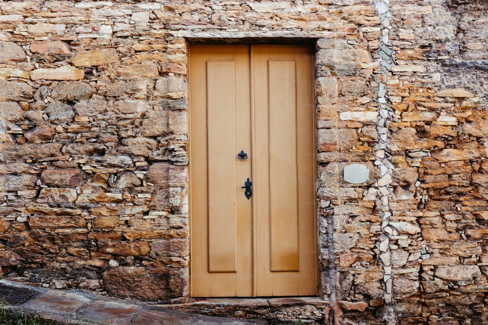 ein Steingebäude mit einer Holztür und einem Fenster