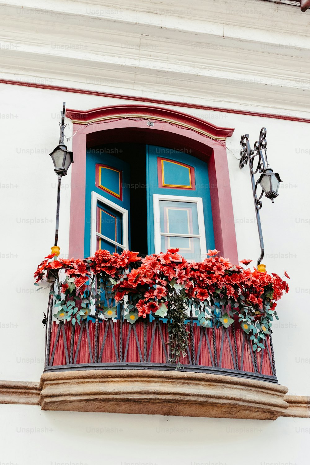 une boîte de fenêtre rouge et bleue avec des fleurs dessus