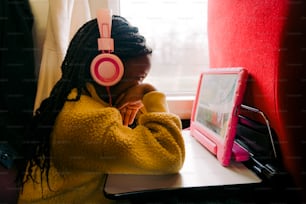 a young girl wearing headphones sitting at a desk