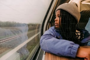 Une femme regardant par la fenêtre d’un train