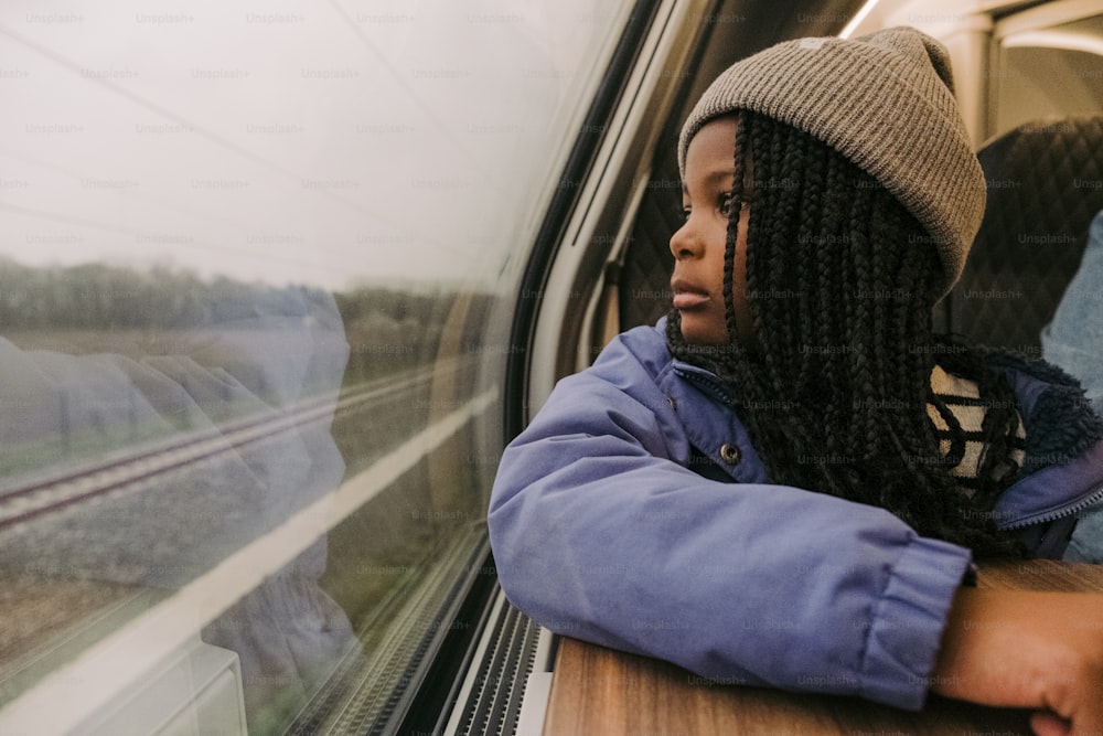 電車の窓の外を眺める女性