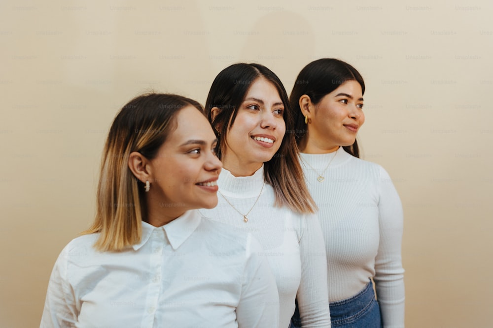 a group of three women standing next to each other