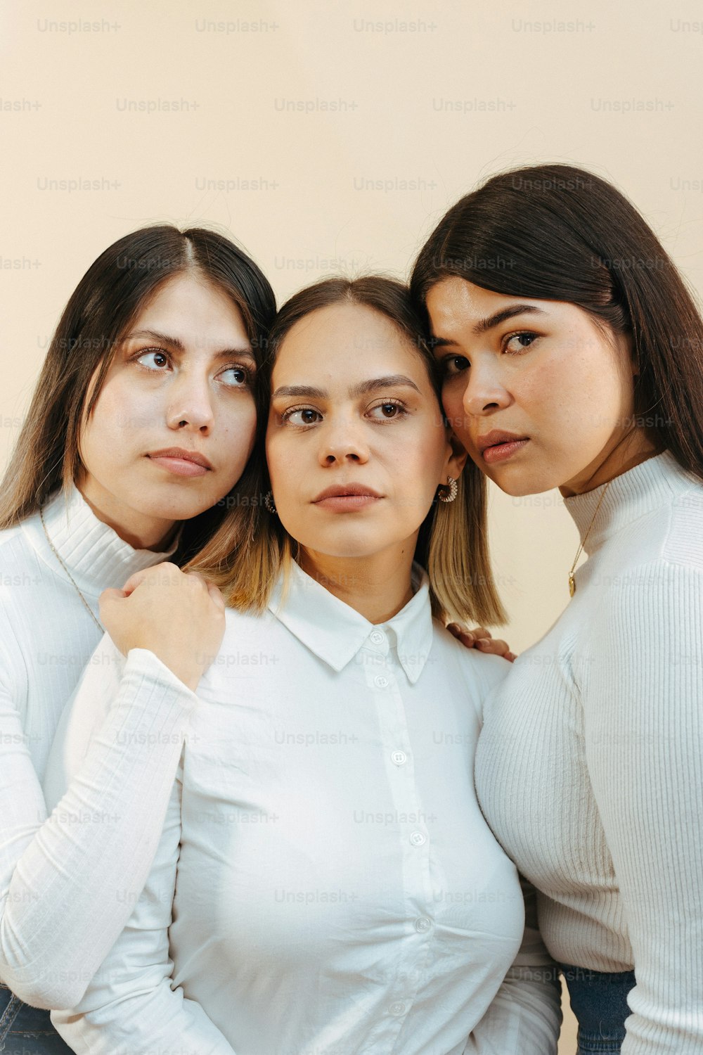 um grupo de três mulheres de pé uma ao lado da outra