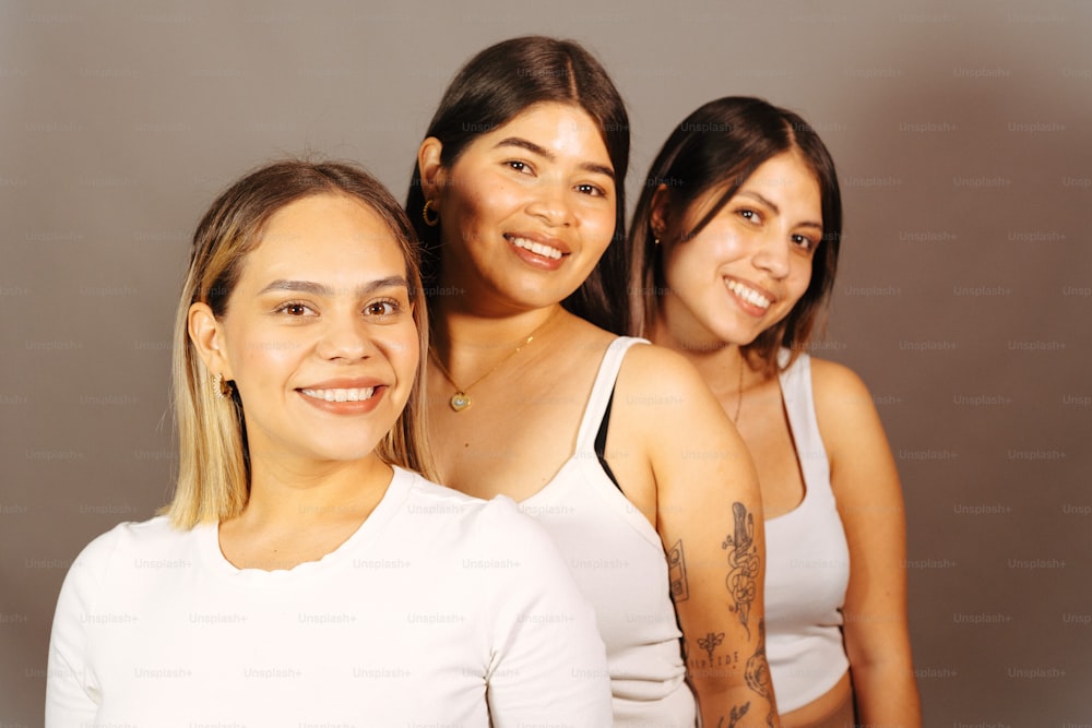 eine Gruppe von drei Frauen, die nebeneinander stehen
