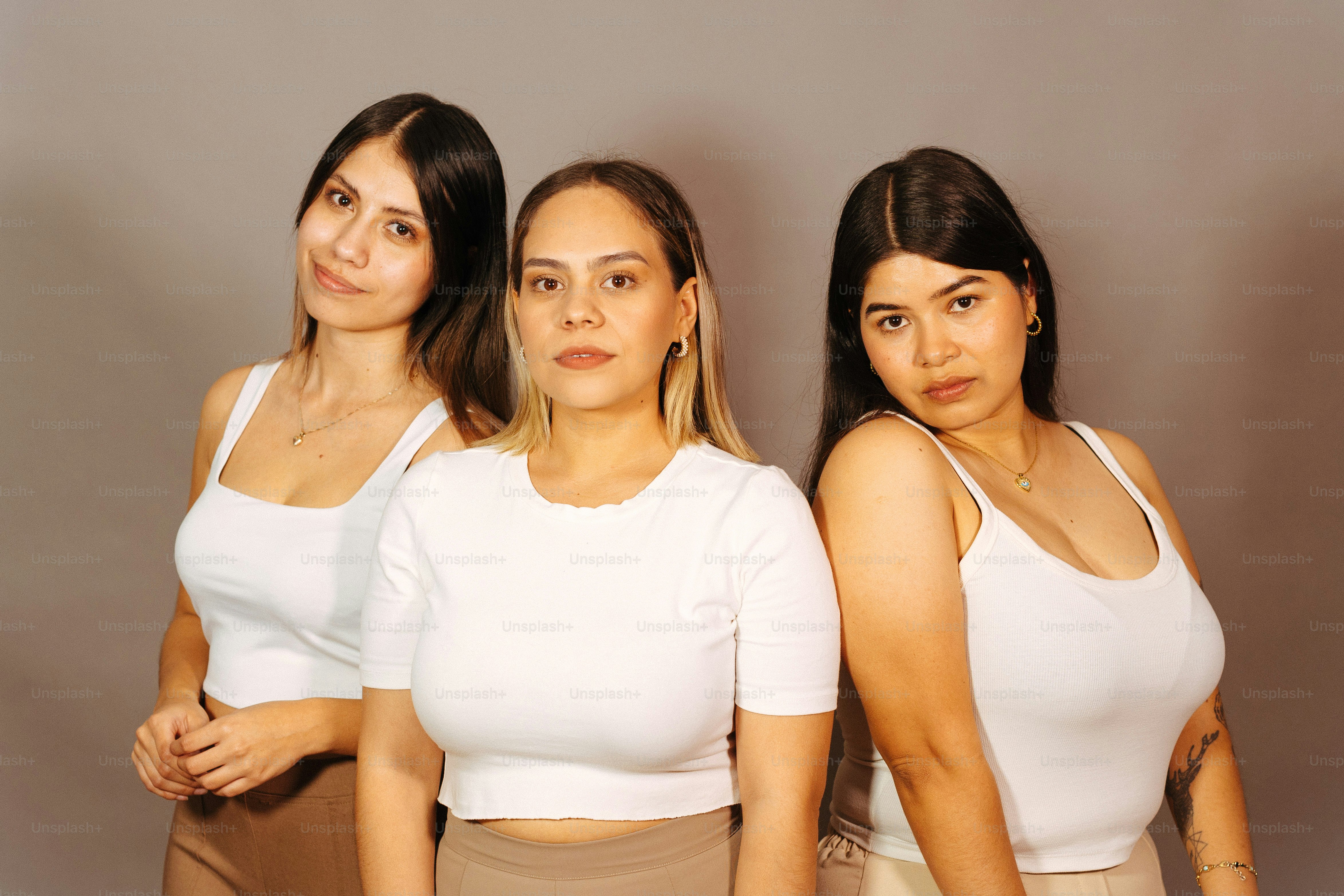 eine Gruppe von drei Frauen, die nebeneinander stehen