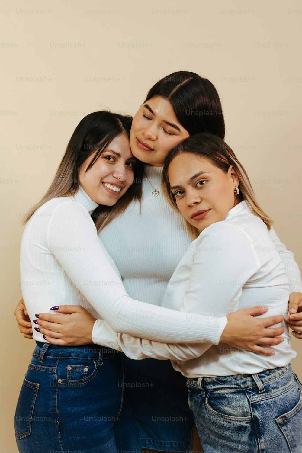 Un grupo de tres mujeres abrazándose